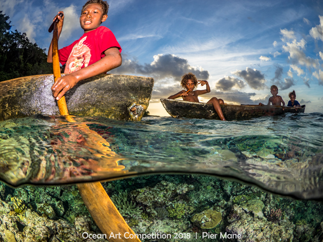 Solomon Island kids in canoes at sunset